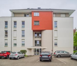 イルキルシュ・グラフェンスタデンにあるLe Nid Azurの駐車場に車が駐車されている建物