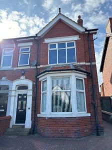 a red brick house with a large window at The Links House Lytham St Annes in Lytham St Annes