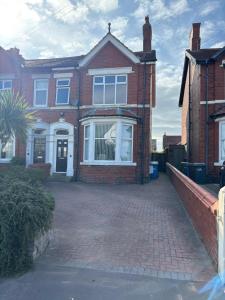 a large brick house with a brick driveway at The Links House Lytham St Annes in Lytham St Annes