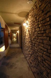 un pasillo con una pared de ladrillo con una luz encendida en Hotel Luandon Shirahama, en Shirahama
