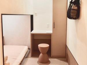 a small bathroom with a toilet and a sink at HOTEL minimumms女性専用カプセルホテルWomen only hotel in Naha