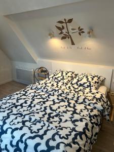 a bedroom with a bed with a blue and white comforter at Appartement Duplex -Vue sur mer- à 100 m de la plage in Le Portel