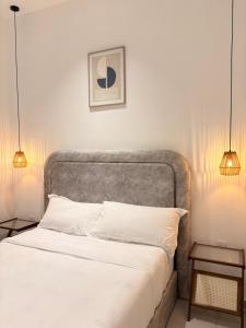 a bedroom with a bed with white sheets and two lamps at Arouna Villa Private Pool in Dungun