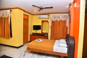 a bedroom with a bed and a mirror at Hotel Grand Palace in Coimbatore