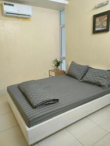 a bed in a white room with avertisementatronatronstrationstrationstration at Nhật Minh Motel Hải Phòng in Hai Phong