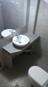 a bathroom with a sink and a toilet at Evanthia Toroz Rooms & Studios in Mythimna