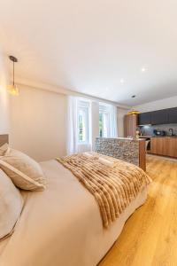 a large bed in a room with a kitchen at Le Refugo in Allevard
