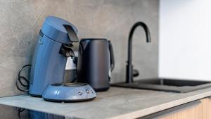 a blue mixer sitting on a counter next to a sink at Le Refugo in Allevard