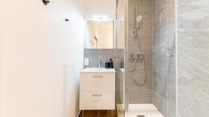 a bathroom with a shower and a white sink at Le Refugo in Allevard