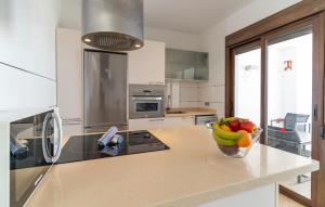 Una cocina con un bol de fruta en la encimera. en Amazing Home In Torrox Costa, en Torrox Costa