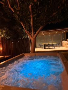 a large pool of water in a backyard at night at Villa Repsimia with Private Jacuzzi in Kókkinos Pírgos