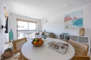 a white dining room with a white table and chairs at Casa A in Olhos de Água