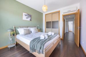 a bedroom with a large bed with towels on it at Casa A in Olhos de Água +17 photos