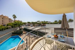 a balcony with a table and a swimming pool at Casa A in Olhos de Água