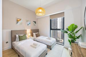 迪拜Brand new 2BR in Downtown 5 min walk to Burj Khalifa的一间有两张床和一扇大窗户的卧室 更多51张照片