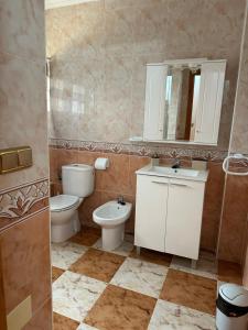 a bathroom with a toilet and a sink and a mirror at Playa Golf II Campoamor in Los Dolses