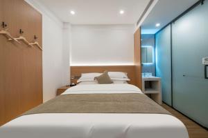 ein Schlafzimmer mit großem Bett und ein Badezimmer in der Unterkunft Fenghuang Luming B&B in Fenghuang