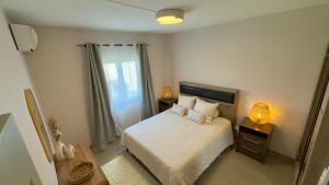 Un dormitorio pequeño con una cama y una ventana. en Zephyr House Ocean View, Rooftop & Pool, en Grand Gaube