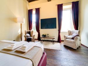 1 dormitorio con 1 cama, 2 sillas y TV en Domus Corsini, en Roma