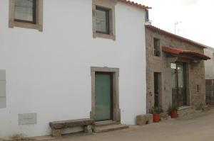 een wit gebouw met een bank ervoor bij Casa de l Telar in Duas Igrejas