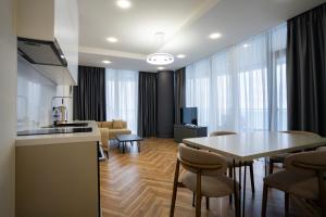 a kitchen and living room with a table and chairs at Solis Residence Aparthotel in Batumi