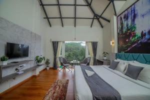a bedroom with a large bed and a tv at Bestinn Leisure Myst Private Villa Ooty in Ooty