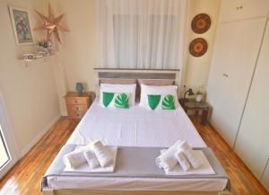 a bedroom with a bed with green and white pillows at Helios Apt in Kastoria