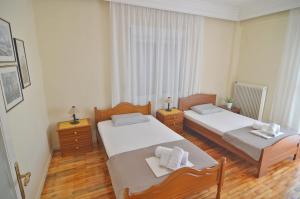 a bedroom with two beds and a table and chairs at Helios Apt in Kastoria