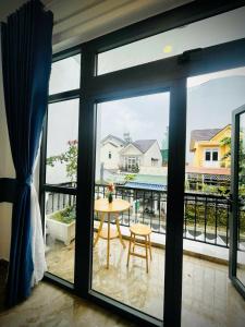 una vista su un balcone con tavolo e finestra di August Inn Da Lat a Da Lat