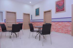 a room with chairs and tables and a brick wall at Capital O 2018 Ring Road Guest House Syariah in Banda Aceh