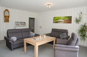 a living room with two couches and a coffee table at Ferienhaus Voß, 65260 in Moormerland
