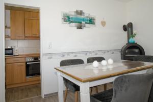 a kitchen with a table and chairs and a stove at Ferienhaus Voß, 65260 in Moormerland