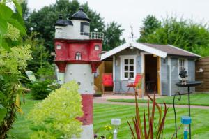 a red and white lighthouse in front of a house at Ferienwohnung Nordbrock, 65317 in Moormerland