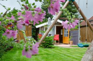 a house with pink flowers in the yard at Ferienwohnung Nordbrock, 65317 in Moormerland
