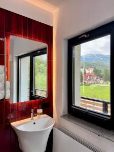 a bathroom with a sink and a window at Greg Rooms in Sinaia