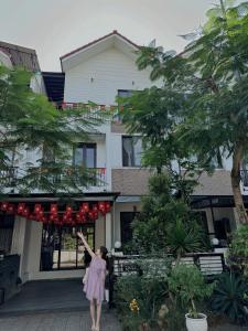 Eine Frau steht vor einem Haus in der Unterkunft Bliss Homestay Huế in Thôn Lại Thê