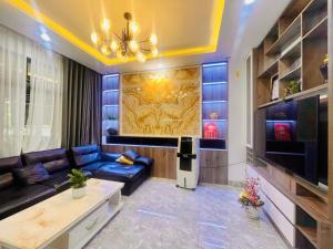 ein Wohnzimmer mit einem blauen Sofa und einem Fernseher in der Unterkunft Bliss Homestay Huế in Thôn Lại Thê