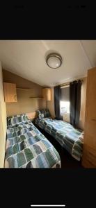 une chambre avec deux lits et une fenêtre dans l'établissement Winkups Getaway caravan hire, à Kinmel Bay