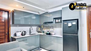 a kitchen with a refrigerator and a sink at Rawsons Crib 2Bedroom Unit in Horizons 101 in Cebu City