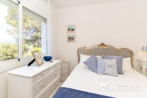 ein Schlafzimmer mit einem Bett mit einer Kommode und einem Fenster in der Unterkunft Casa Sian Retreat near Sitges in Olivella