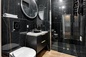 a black bathroom with a toilet and a shower at Cozywave Apartments in Palanga +17 photos