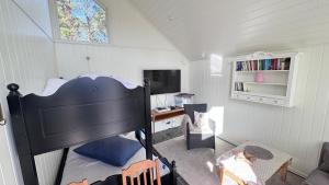a room with a bed and a desk and a window at Litla Hyttå, Mosterhamn Bømlo in Mosterhamn