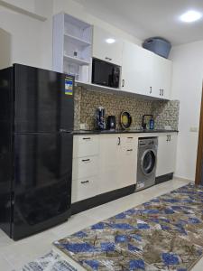 a kitchen with a refrigerator and a washing machine at Golden Tiba in Hurghada +9 photos
