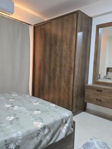 a bedroom with a bed and a large wooden cabinet at Golden Tiba in Hurghada