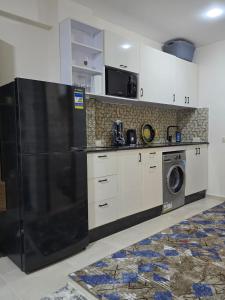 a kitchen with a black refrigerator and a dishwasher at Golden Tiba in Hurghada