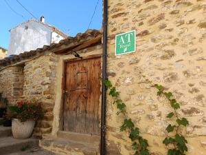an exit sign on the side of a stone building with a door at La Sabina in Terriente