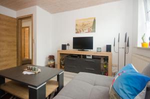 a living room with a couch and a table at Ferienwohnung Nordbrock, 65317 in Moormerland +16 photos
