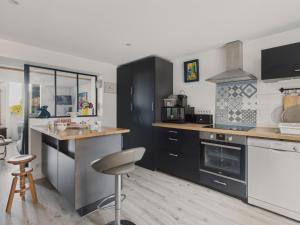 a kitchen with black cabinets and a counter top at Maison avec accès privatif direct à la plage pour 6 in Pornichet +19 photos