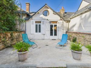 a patio with two blue chairs in front of a house at Maison avec accès privatif direct à la plage pour 6 in Pornichet