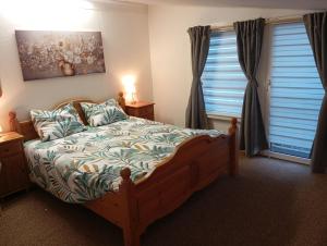 a bedroom with a bed and two windows at Ferienhaus Max Schmeling in Benneckenstein
